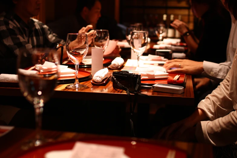 people sitting at a table with wine glasses on it