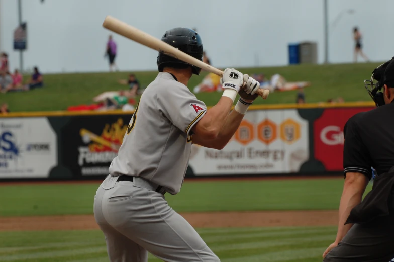 a man in a baseball uniform holds a bat on a field