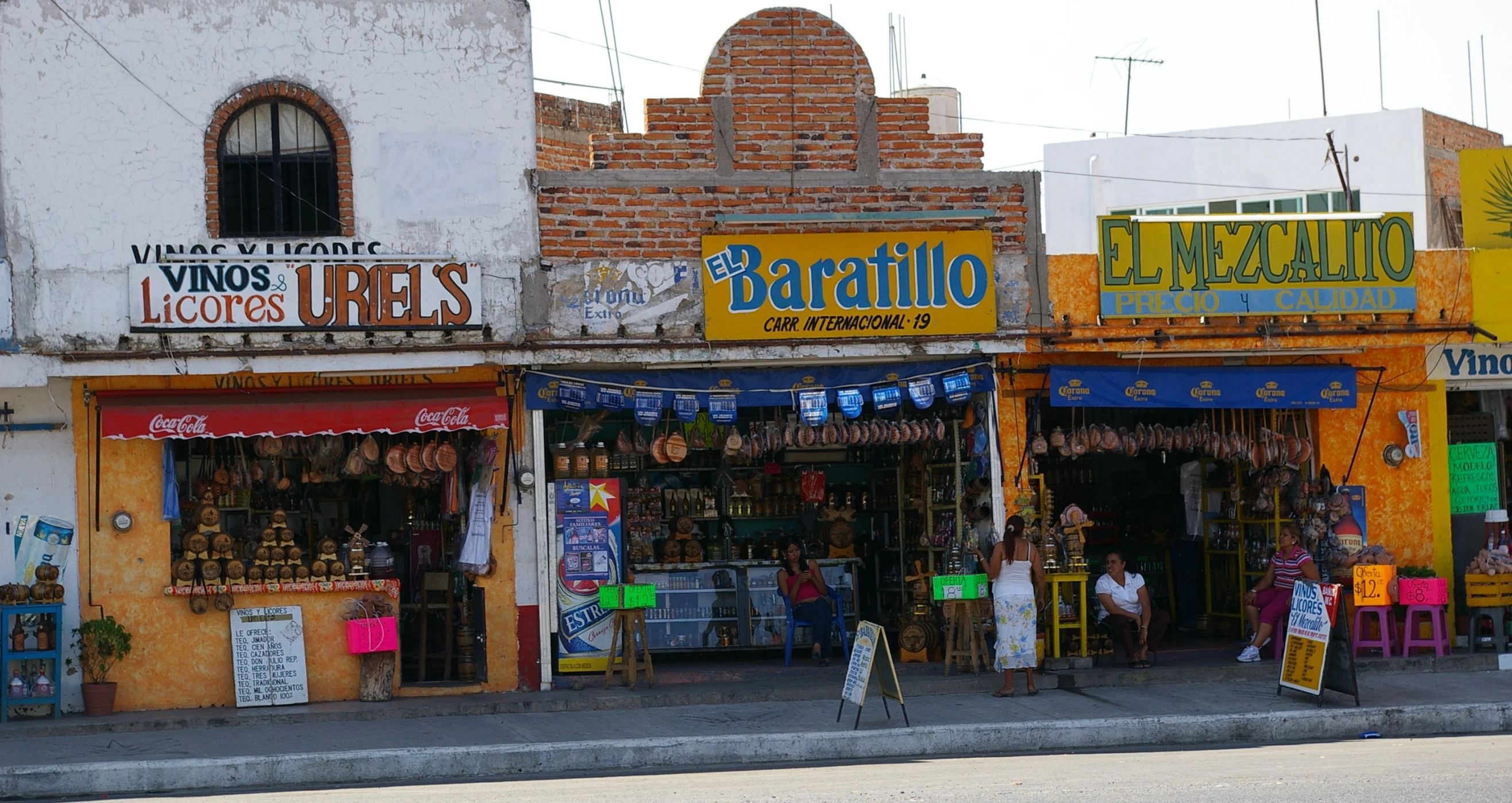 several store fronts on a street lined with buildings