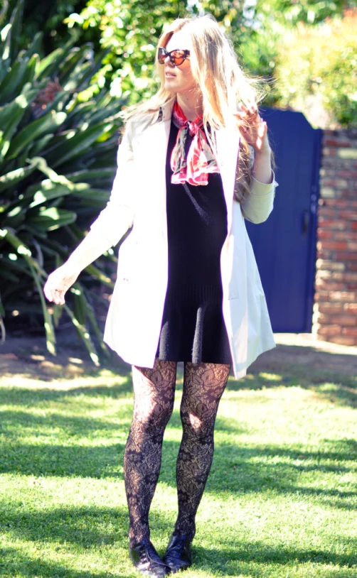 a woman walking across a lush green grass covered park