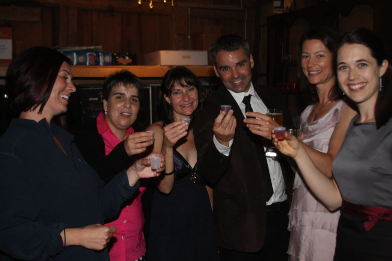 a group of people at a party smiling and drinking