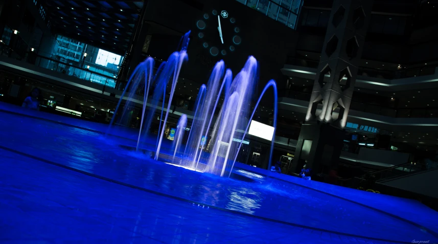 water gush out from a big blue surface in front of some buildings
