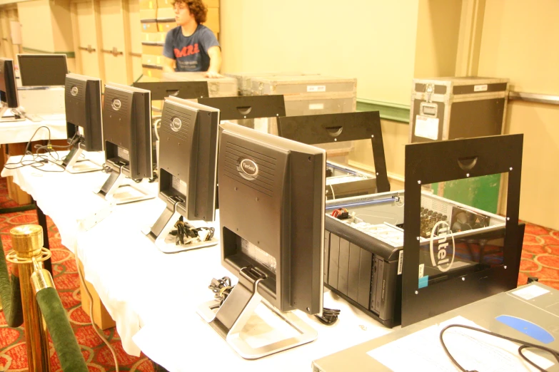 computer monitors in rows on a table at a tech conference