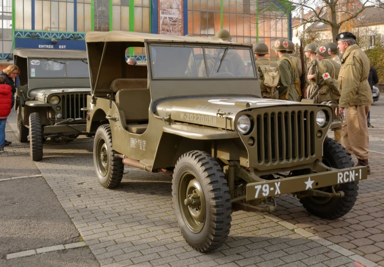 an army jeep with some military officers standing in front of it