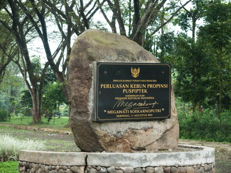 a stone statue of a large rock in a park