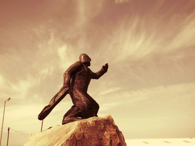 the statue is sitting on a rock next to a building