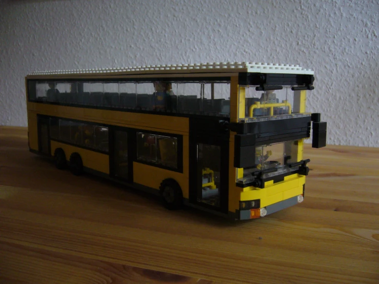 a yellow lego bus on a table with other items around