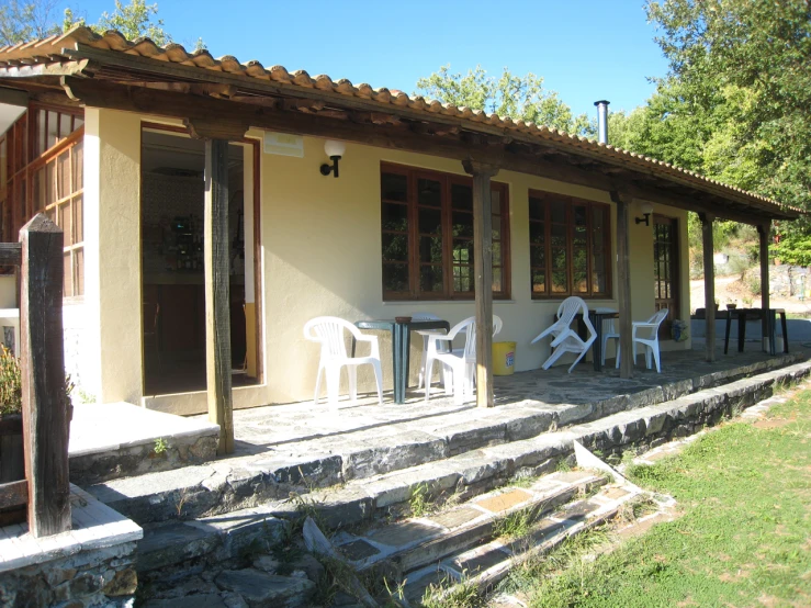 outdoor sitting area with chairs and steps up to a house