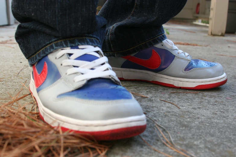 a man is wearing sneakers with blue and red shoes