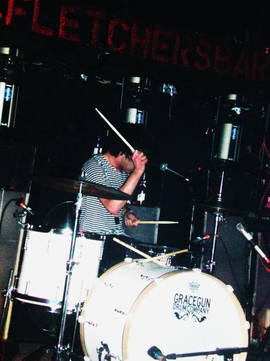 a man standing on stage holding a drum sticks