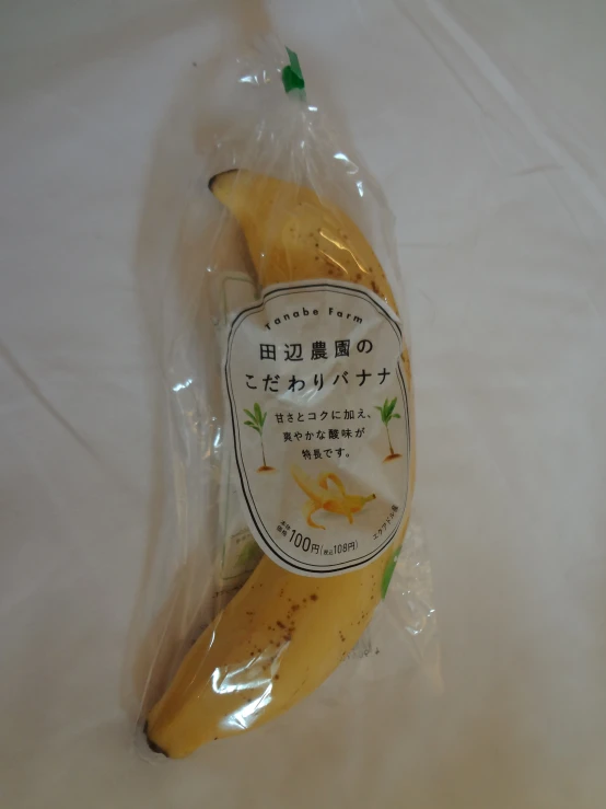 a banana wrapped in plastic on a white cloth