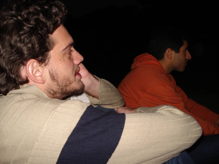 two men are sitting together looking off into the distance