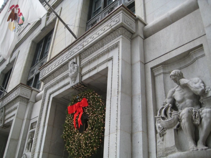 a building with a christmas decoration with red ribbon and a wreath