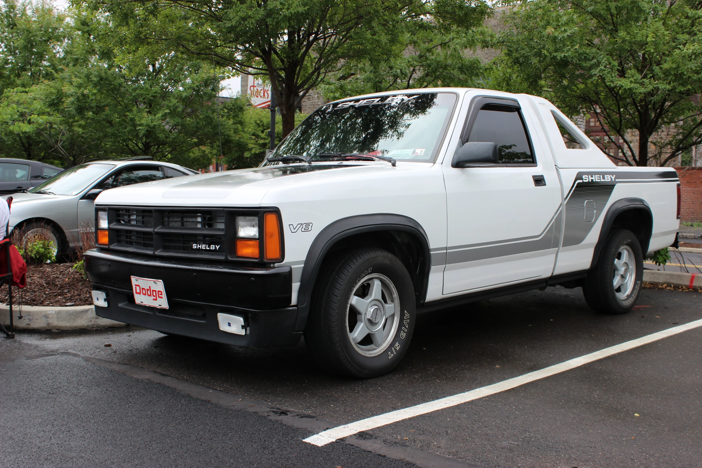 a white truck in a parking lot next to trees