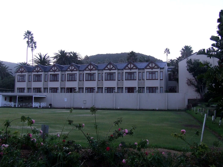 a large building with tall windows surrounded by lots of green grass