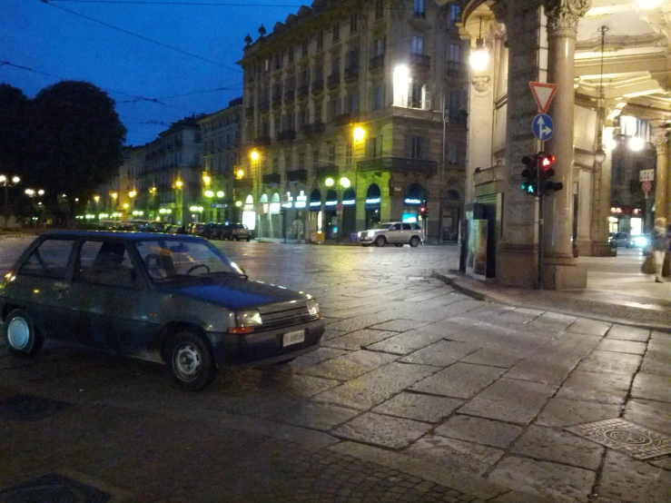 an old green car in front of a building