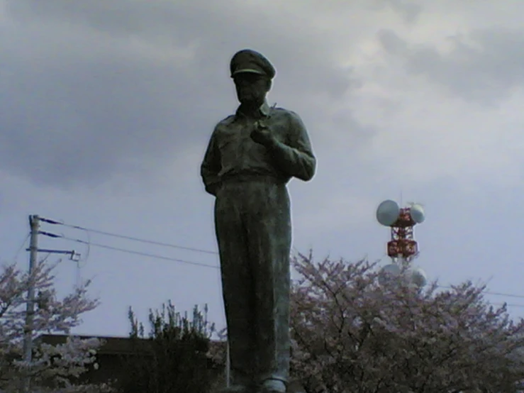 a sculpture of a man in uniform, holding a cell phone