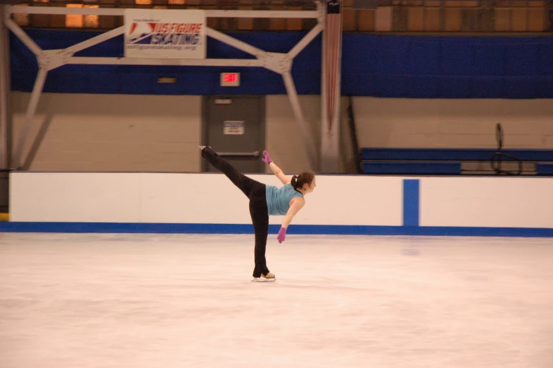 woman on ice skating at rink doing tricks