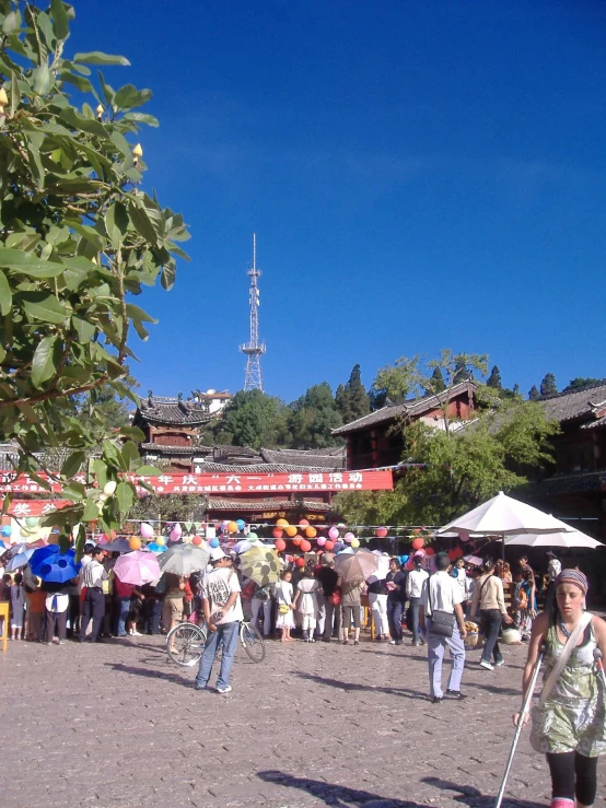 a crowd walking down a street with a bunch of umbrellas