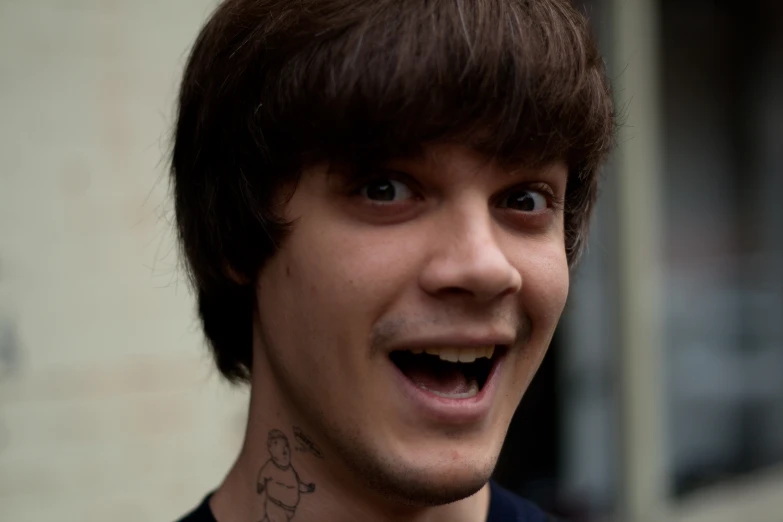 a young man with brown hair smiling at the camera