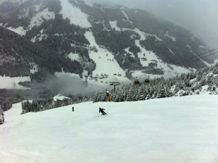 a group of people riding skis down a snow covered slope