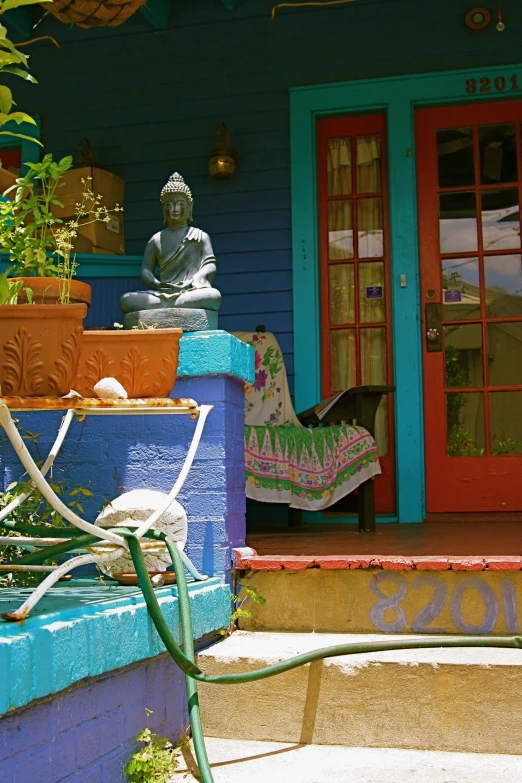 a blue house with a buddha statue outside of it