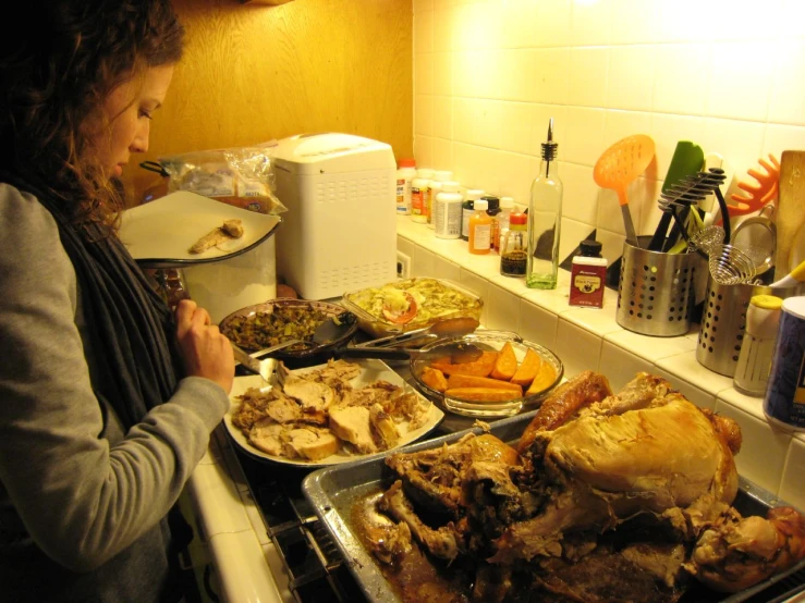 a woman preparing a bunch of food in a kitchen