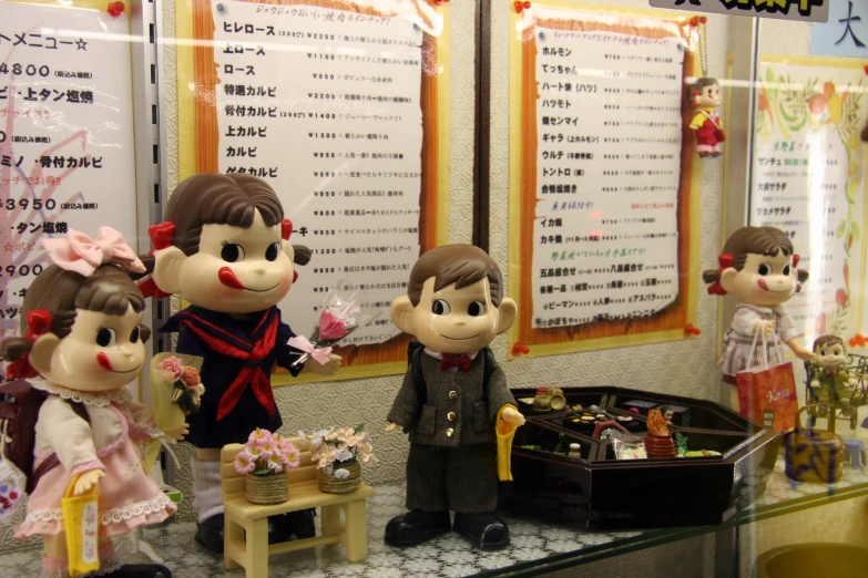 an asian shop display of well decorated dolls