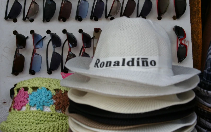 several hats and sunglasses next to an eyeglass display