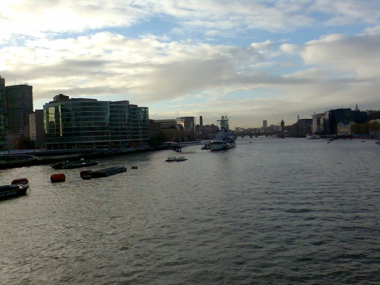 a river with boats sailing in it and cloudy skies