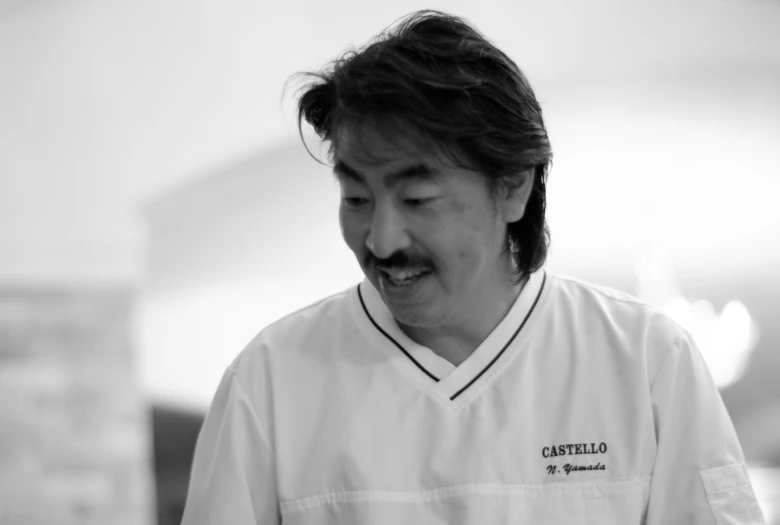 a chef is smiling while holding soing in his hand