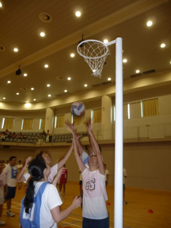 a basketball player reaching into a ball near a hoop