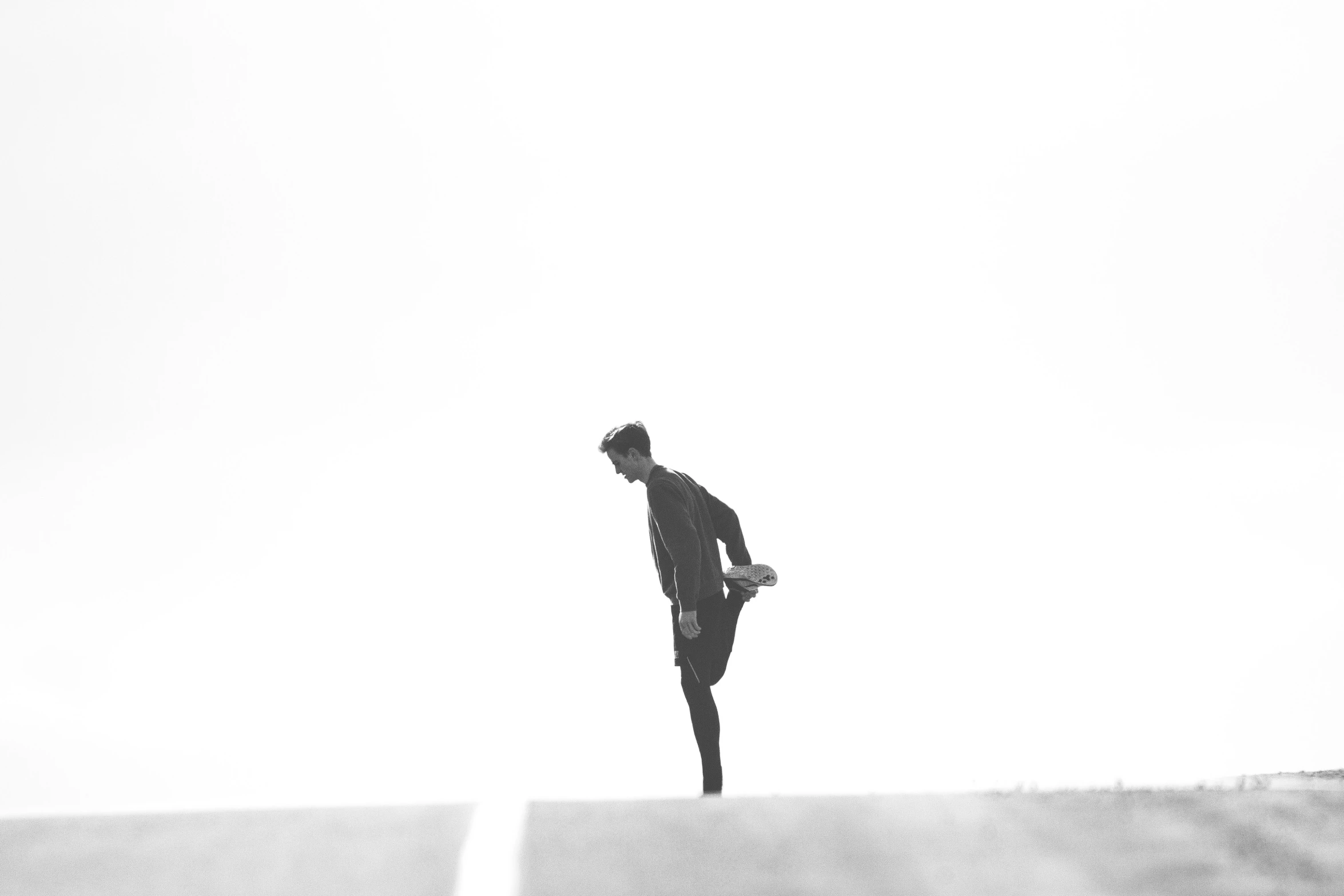 a man stands on a large mound wearing his feet apart