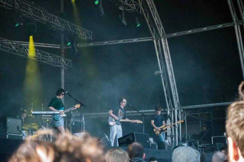 people at an outdoor concert singing and playing instruments