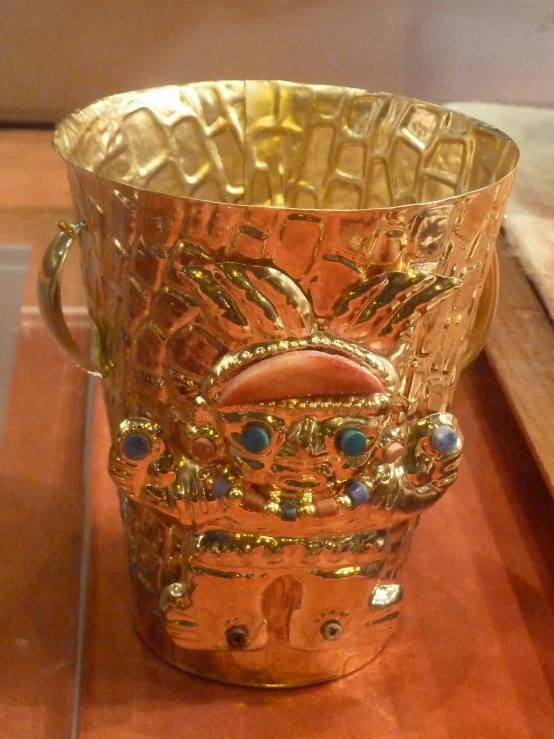 a glass cup with gold design on it