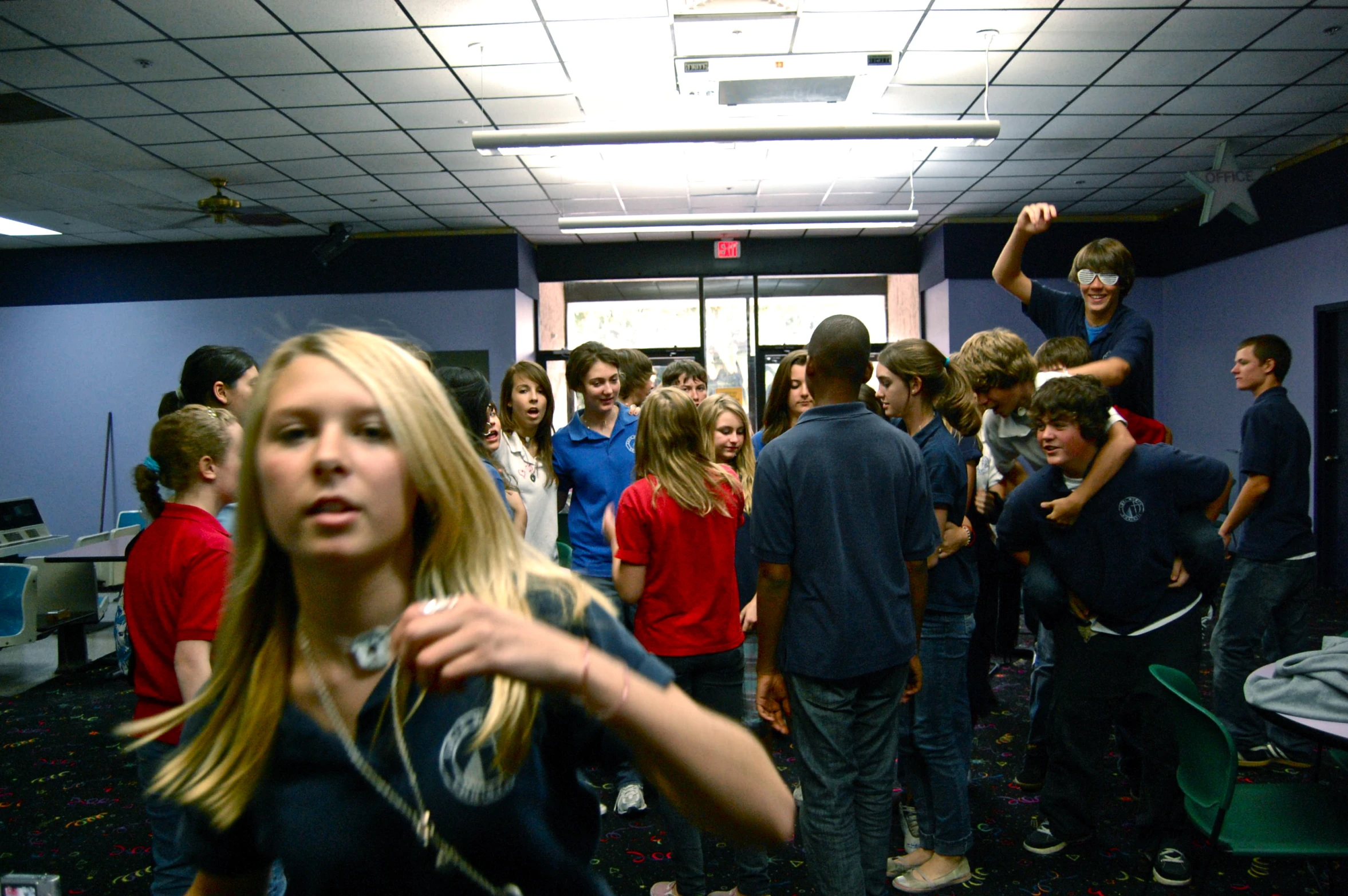 a man and woman play video games in a crowded room