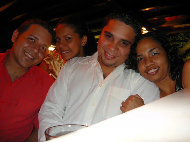 several people are smiling for the camera and one is wearing a red shirt