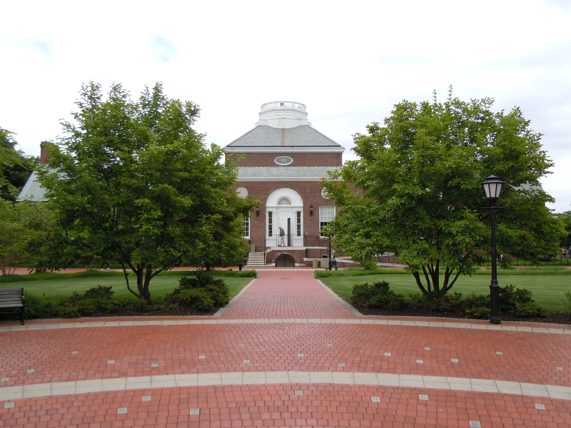 a brick walkway leads to a large building