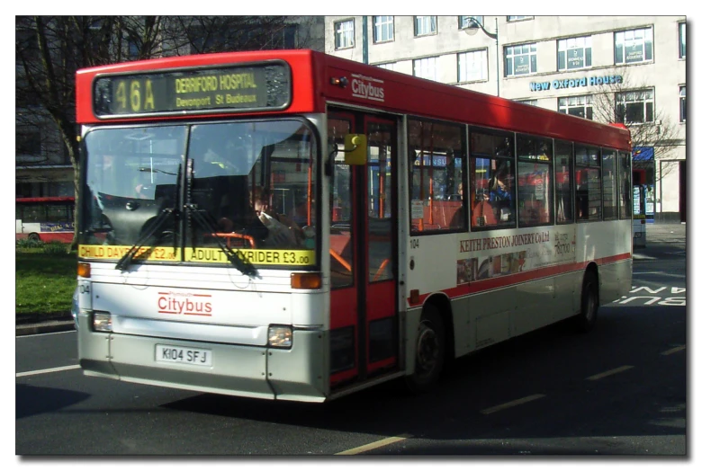 a bus with the doors open driving down a city street