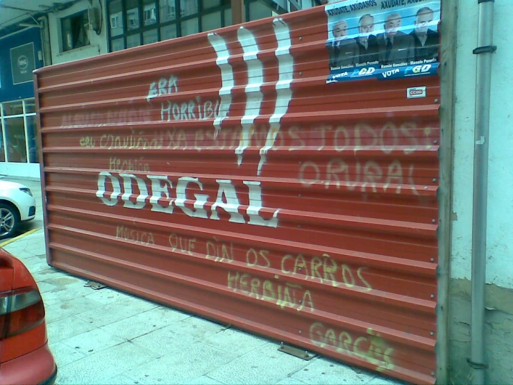 a large red wall has graffiti written on it