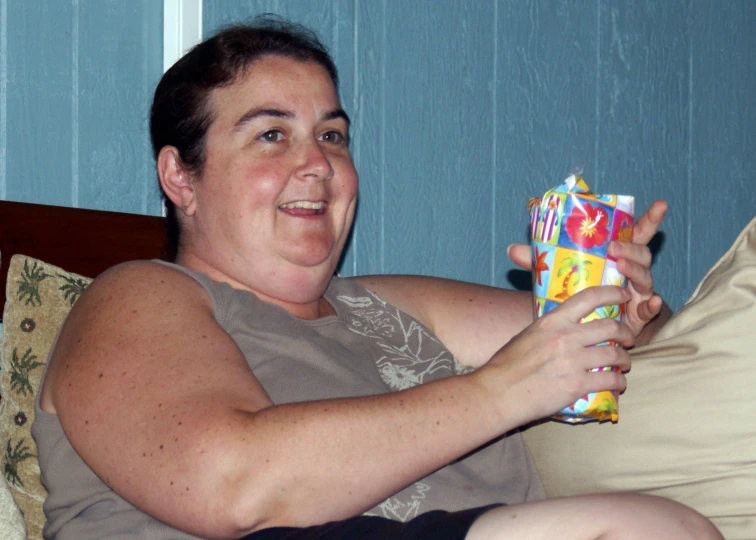 a women holding a present on the couch