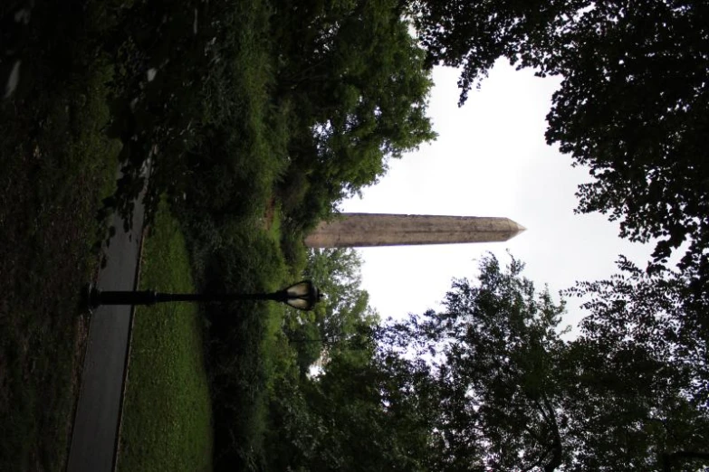 a tall obelisk with trees surrounding it
