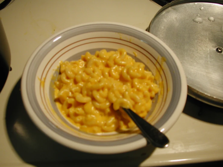 a bowl of macaroni and cheese is sitting on the stove