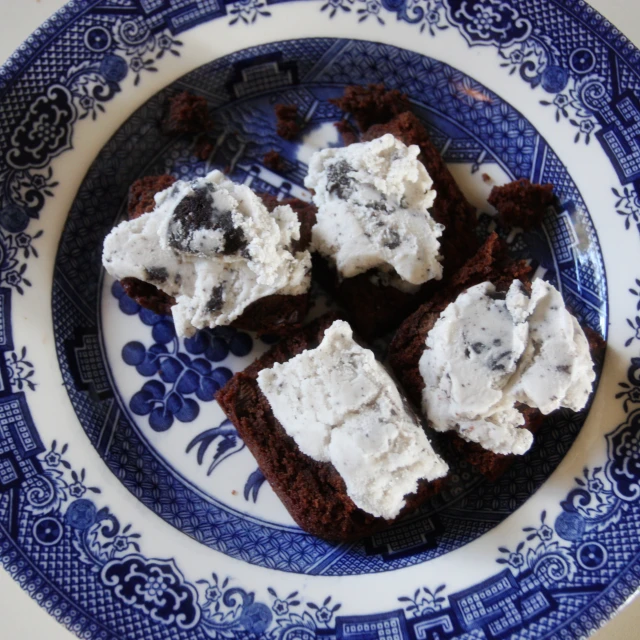 four brownies sitting on top of a blue and white plate