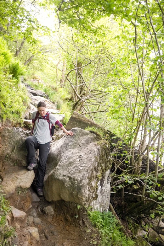 a person with backpack on on a path near rocks