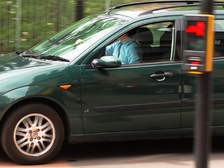 a green vehicle with a person sitting in the driver's seat