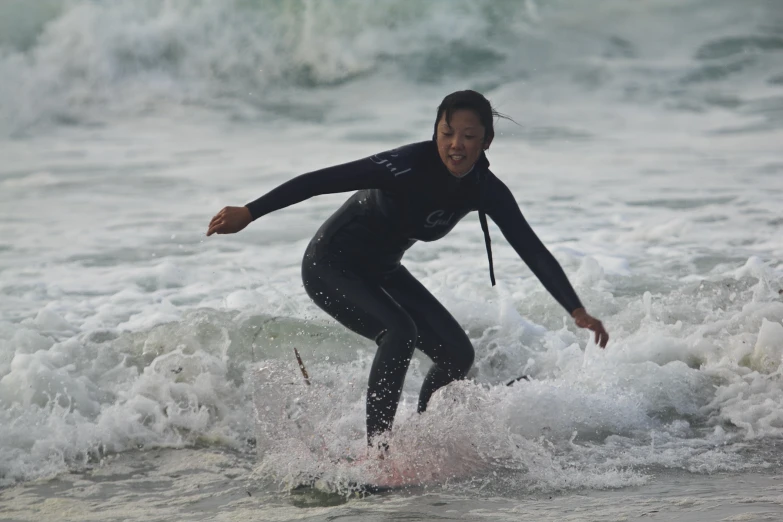 the woman is surfing on a very small wave