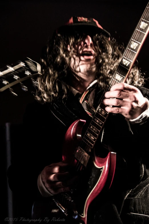 a man playing a guitar in the dark