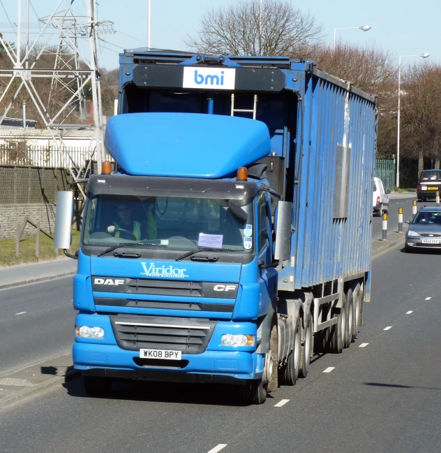 a blue semi truck driving down the road