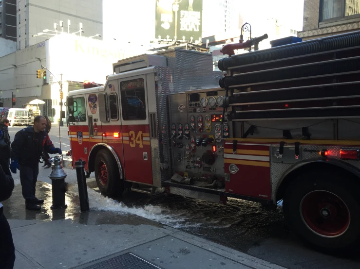 a large firetruck sitting on top of a street next to people